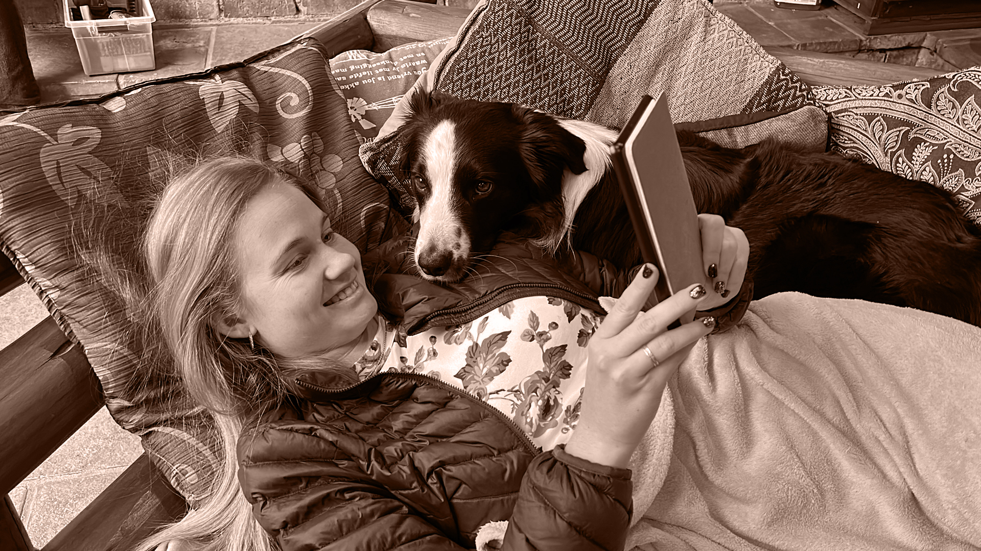 Altia reading while cuddling a dog
